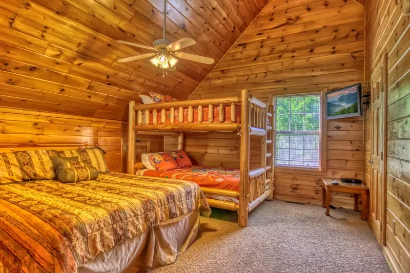 Redneck Ritz cabin bedroom with queen bed and bunk bed