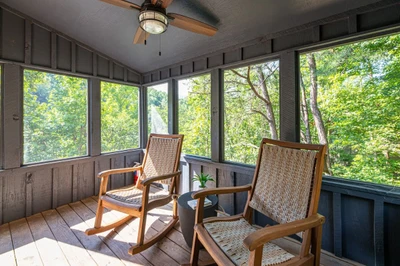 This sunroom includes rocking chairs and offers cozy reading vibes.