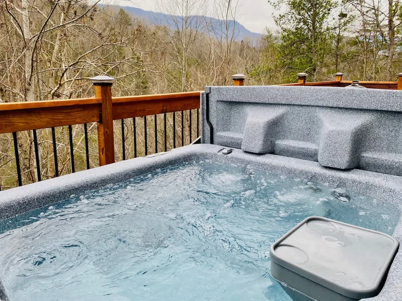 The hot tub is located to the right of the living room entrance.