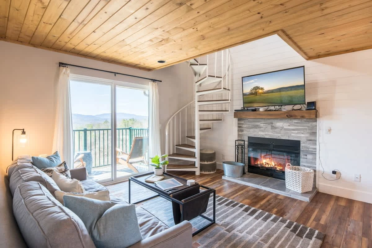 Living area with access stairs to loft & private balcony