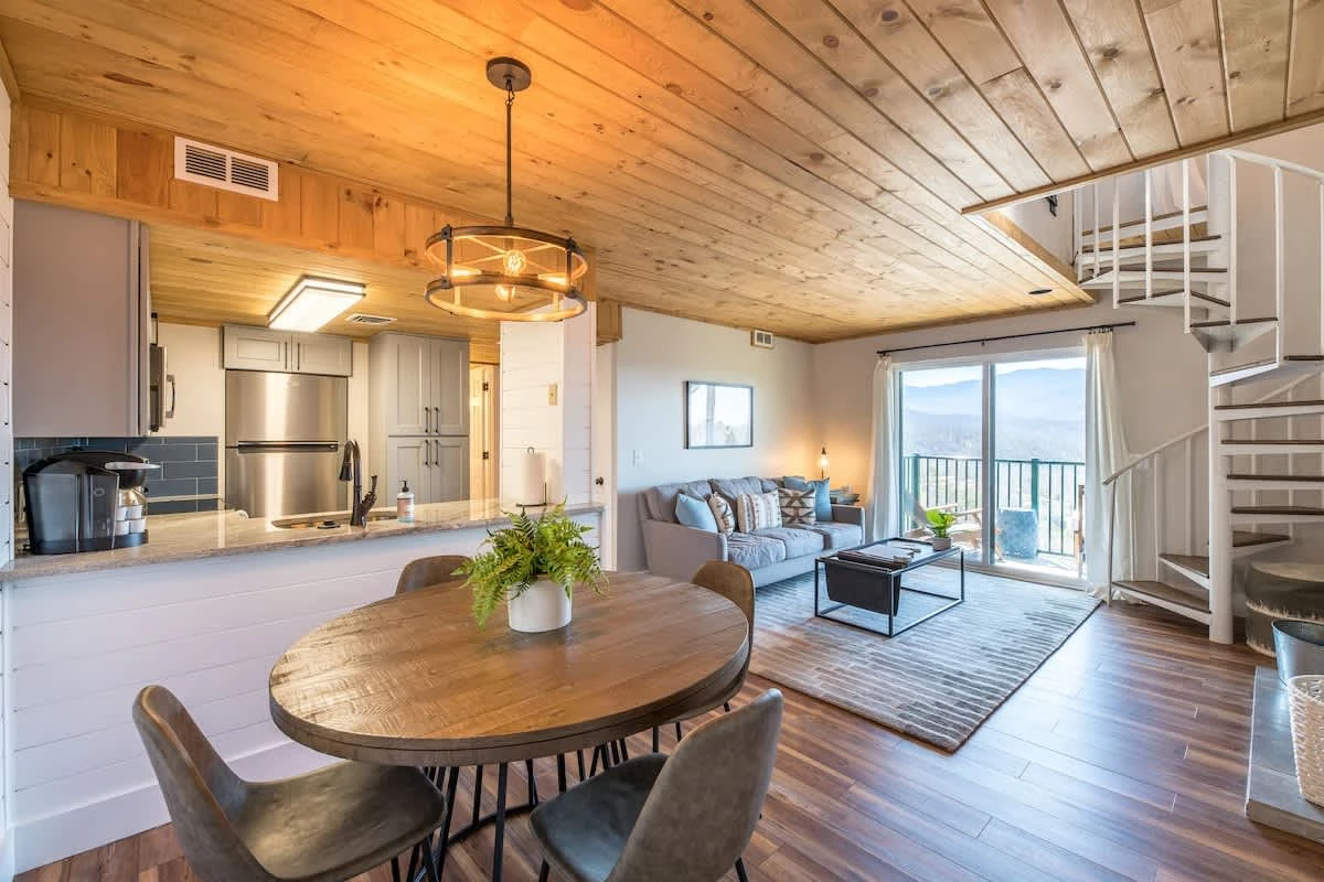 Open living & dining area with access stairs to loft. Kitchen is to the left of hallway.