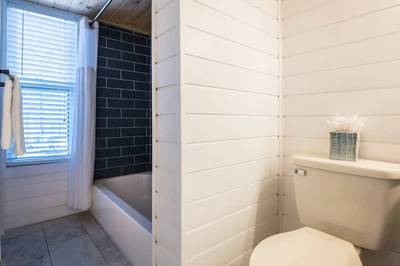 Bathroom features blue-tiled tub/ shower