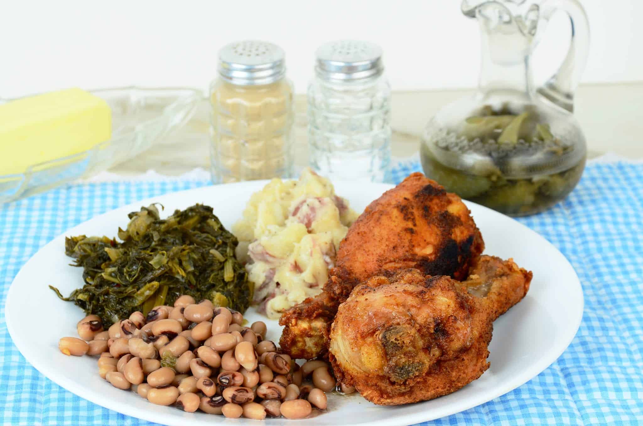 Southern food consisting of fried chicken, greens, beans, and mashed potatoes