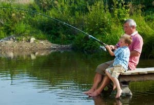 grandfather and grandson fishing on dock