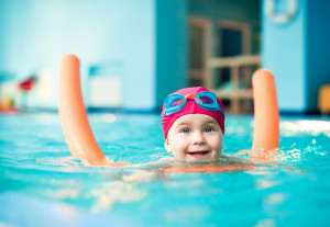 happy little girl swimming in a Gatlinburg cabin with indoor pool