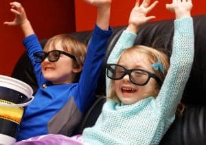 two kids enjoying a movie in a theater room