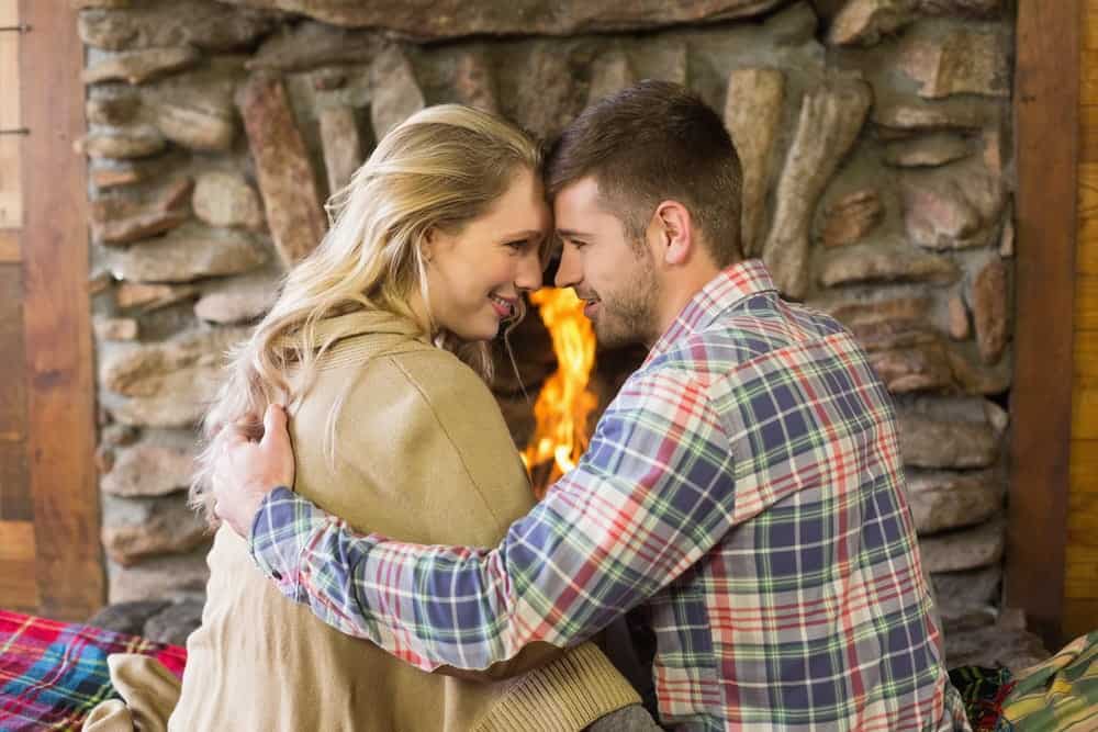 Happy couple in front of the fireplace at our romantic Gatlinburg cabins.