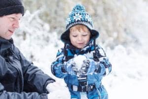 Father and son playing in the snow.